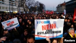 FILE - Protesters carry banners reading 'No refugee home' during an Austrian Freedom Party (FPOe) demonstration in Vienna, March 14, 2016. 