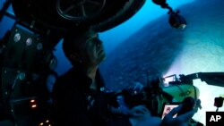 Submersible pilot Robert Carmichael looks out of the submersible as he navigates strong currents during a dive to 400 feet below the surface on Monday April 8, 2019. 