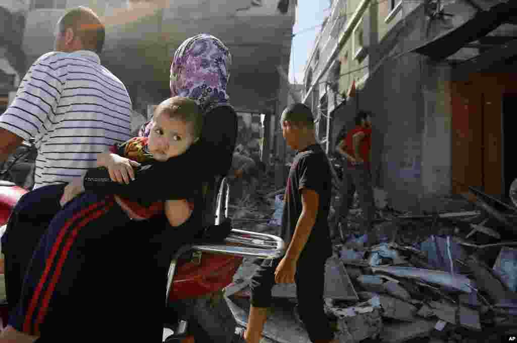 A Palestinian woman holds her son as residents return to Beit Hanoun, northern Gaza Strip, August 1, 2014.