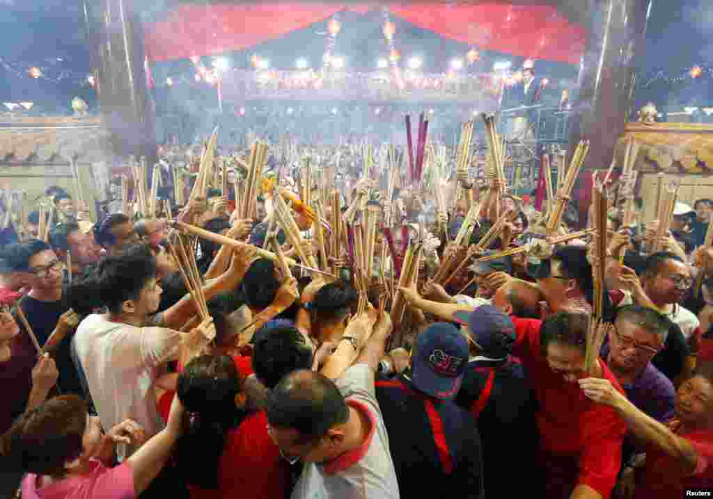 People wait to plant the first joss stick of the Lunar New Year of the Pig at the stroke of midnight at the Kwan Im Thong Hood Cho temple in Singapore.