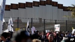 Publik berbaris mendukung kafilah migran di sepanjang perbatasan di San Diego, Minggu, 25 November 2018. (Foto: dok).