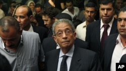 Egyptian presidential candidate Amr Moussa, center, attends a news conference in Cairo, May 16, 2012.