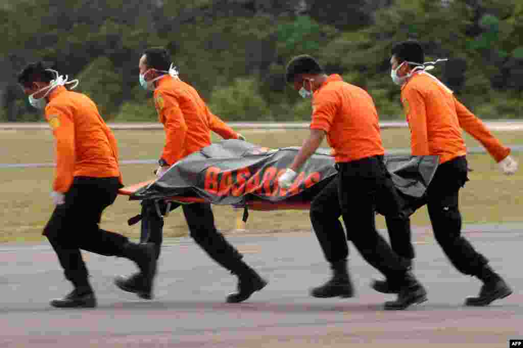 Members of an Indonesian search and rescue team carry a dead body on a stretcher during the recovery of victims who were onboard the crashed AirAsia flight QZ8501 in Pangkalan Bun.