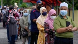 Voters line up to enter a voting center on the outskirts of Malacca, Malaysia, Saturday. Prime Minister Ismail Sabri Yaakob's UMNO-led National Front coalition secured 21 of the 28 state assembly seats.