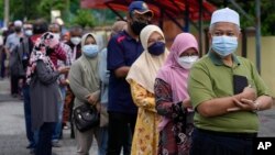 Voters line up to enter a voting center on the outskirts of Malacca, Malaysia, Saturday. Prime Minister Ismail Sabri Yaakob's UMNO-led National Front coalition secured 21 of the 28 state assembly seats.