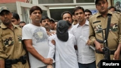 FILE - With his face covered, one of the alleged plotters in the 2008 Mumbai terror attacks is seen in Indian police custody.