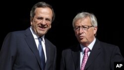 PM Yunani Antonis Samaras (kiri) menerima kunjungan Presiden kelompok Euro Jean-Claude Junker di Athena, Yunani (22/8). 