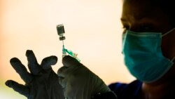 FILE - A syringe is prepared with the Pfizer COVID-19 vaccine at a clinic at the Reading Area Community College in Reading, Penn., on Sept. 14, 2021.