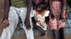 FILE - A girl sits between her leprosy-afflicted parents. A leprosy isolation camp in Bor County’s Malek village, located in South Sudan's Jonglei state, has just received aid supplies for the first time in two years.