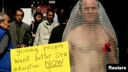 FILE - An activist dressed as a condom protests in Hong Kong, Dec. 1, 2004, the lack of adequate sex education in Hong Kong schools and said the level of HIV infections will rise dramatically because many in Hong Kong are having unprotected sex.