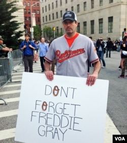 A demonstrator, wearing the uniform of the Orioles baseball team on the street in Baltimore. (VOA photo - Victoria Macchi).