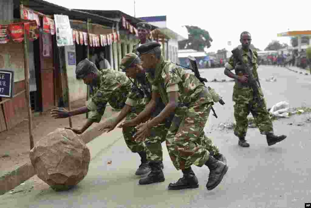 Des soldats roulent un roc que des manifestants ont posé pour bloquer une route à Cibitoke, à Bujumbura, le 22 mai 2015.