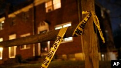 FILE - Crime scene tape that was left behind at the scene of a homicide clings to a fence post in Baltimore, Dec. 21, 2017 photo. 