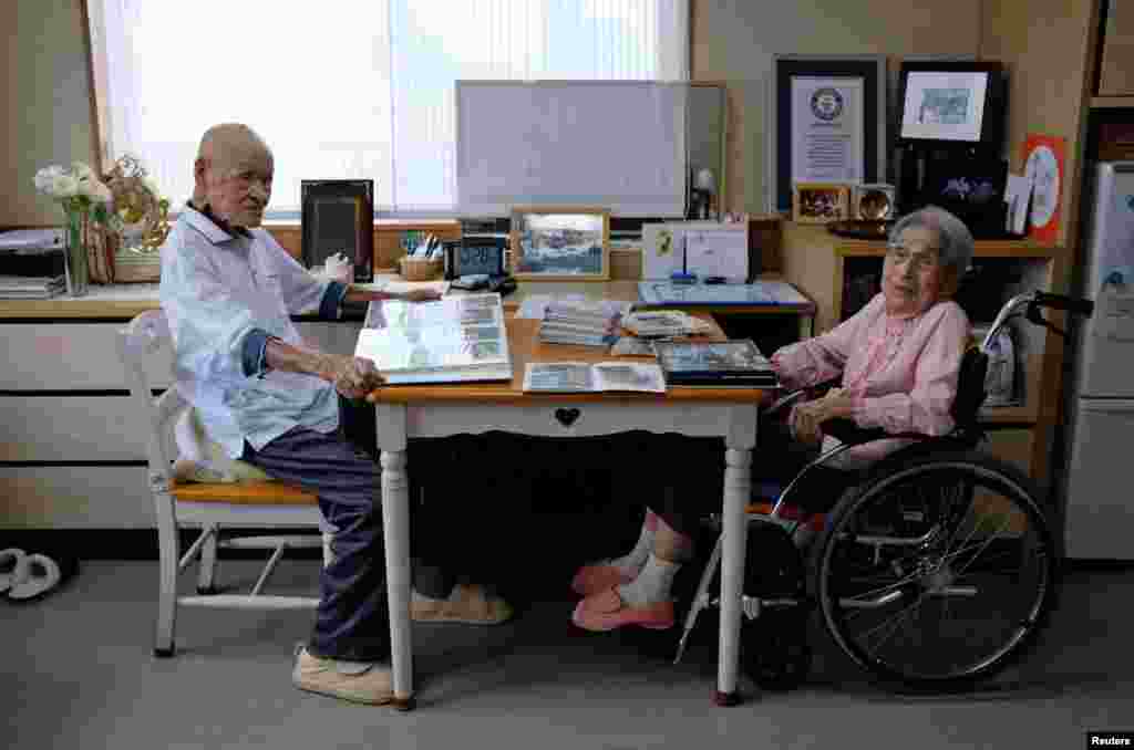 The world's oldest living married couple, Masao Matsumoto (L) and Miyako Matsumoto, look at photo albums in their room at a nursing home in Takamatsu, Kagawa prefecture, Japan.