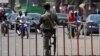 L'officier de police burkinabé monte la garde devant une porte lors de la dernière étape du Tour du Faso 2018, à Ouagadougou, le 4 novembre 2018.