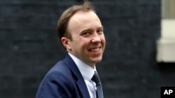 FILE - In this Jan. 9, 2018 file photo, Secretary of State for Digital, Culture, Media and Sport Matt Hancock smiles after leaving a Cabinet meeting in London.