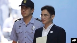 韩国三星电子继承人李在镕（右）在首尔中央地区法院听完判决审理后离开法庭。（2017年8月25日）