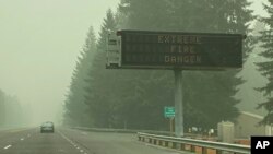 Peringatan kebakaran lahan tampak di selimuti asap kebakaran di Sandy, Oregon, Senin, 14 September 2020. (Foto: AP)