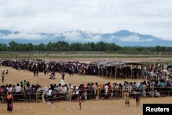 Rohingya refugees line up to receive food at a camp near Teknaf, Bangladesh, Oct. 12, 2017.