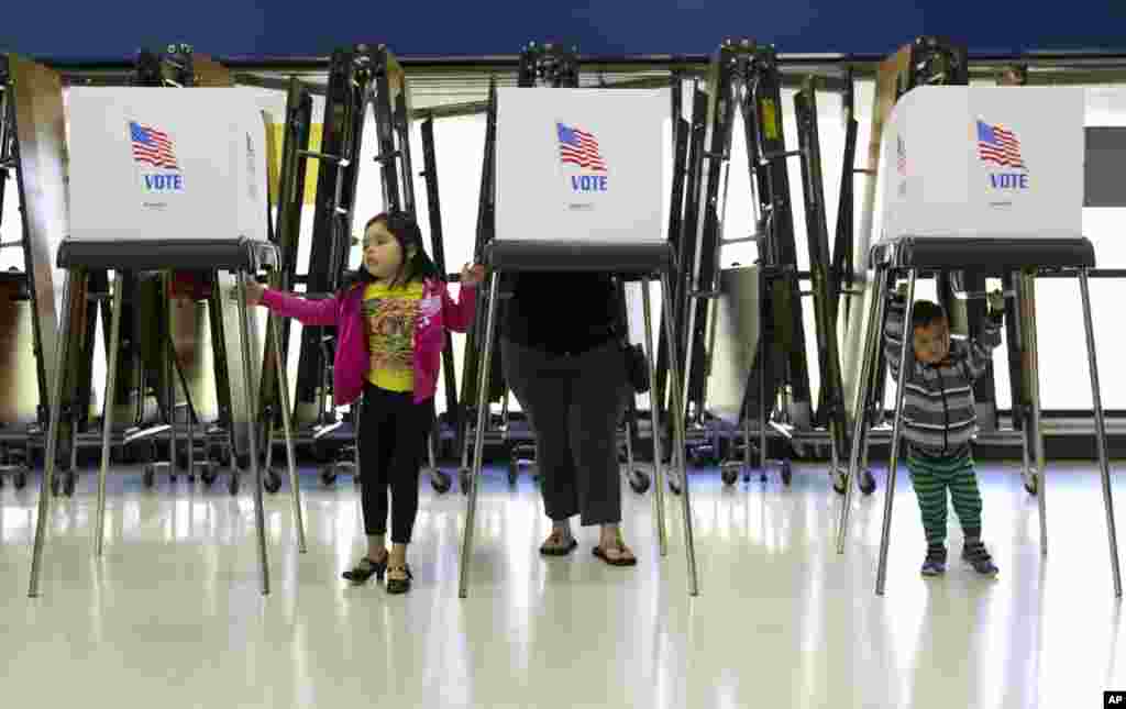 Haileen, 5, and Jason, 2, wait for their mom to cast her ballot at the Langley Park McCormick Elementary School in Langley Park, Maryland.