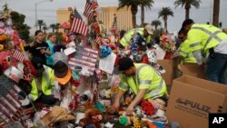 FILE - Workers remove a makeshift memorial honoring the victims of the Oct. 1 mass shooting, Nov. 12, 2017, in Las Vegas. 