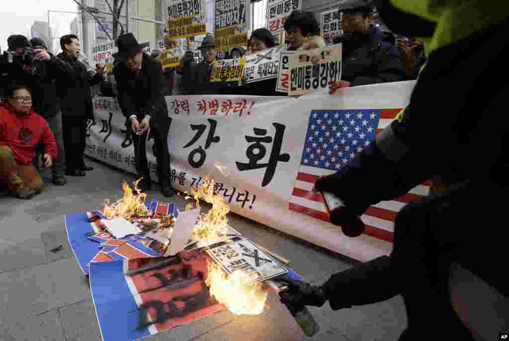 South Korean protesters burn North Korean flags and a photo of the suspect accused of slashing U.S. Ambassador Mark Lippert, in Seoul, South Korea, March 5, 2015.