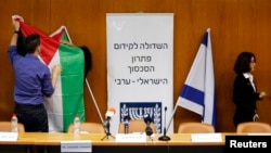 FILE - Israeli parliament employees set up a Palestinian and Israeli flag ahead of a meeting between Israeli parliament members and a delegation of Palestinian politicians and businessmen aimed at encouraging Israeli-Palestinian negotiations, at the Knesset, the Israeli parliament, in Jerusalem, July 31, 2013.