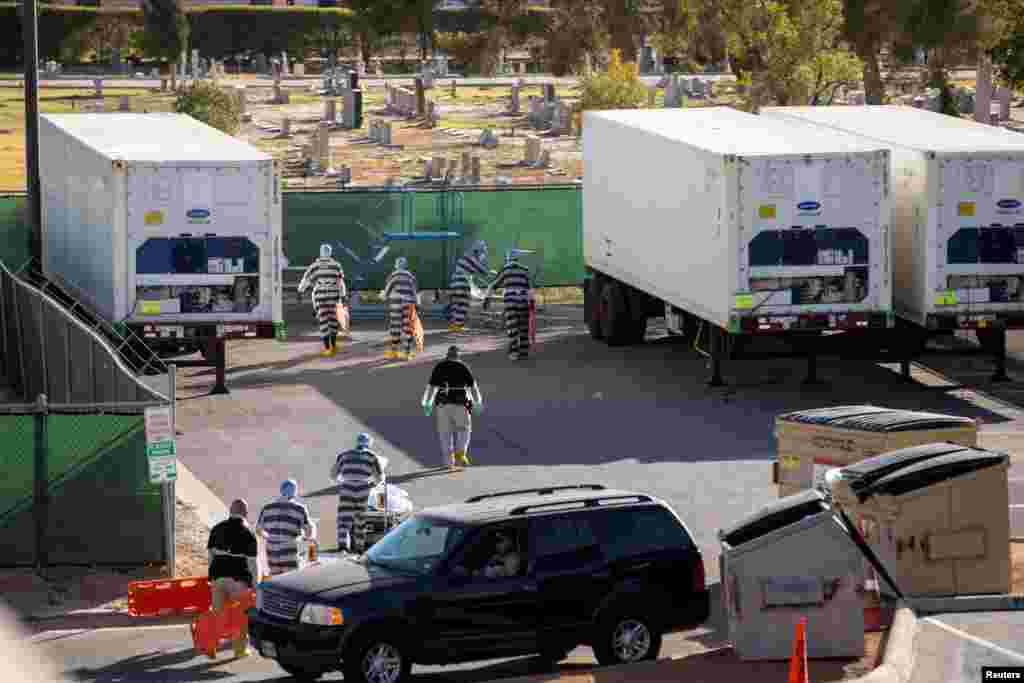 El Paso County detention inmates help move bodies of people who died of COVID-19 to refrigerated trailers outside the Medical Examiner&#39;s Office in El Paso, Texas, Nov. 14, 2020.