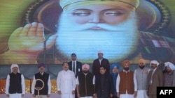 Indian Vice President M. Venkaiah Naidu, third left, stands for the national anthem during the foundation stone-laying ceremony for the planned road corridor to the Pakistan border, at Dera Baba Nanak, Nov. 26, 2018. 