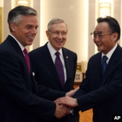 U.S. Senator Harry Reid (D-NV) looks on as U.S. ambassador to China Jon Huntsman (L) shakes hand with Wu Bangguo, chairman of the Standing Committee of the National People's Congress, at the Great Hall of the People in Beijing April 21, 2011