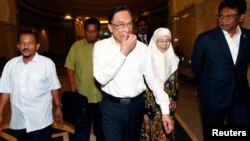 Nhà lãnh đạo đối lập Malaysia Anwar Ibrahim (giữa) và vợ đến tòa án ở Putrajava, Malaysia 7/3/14