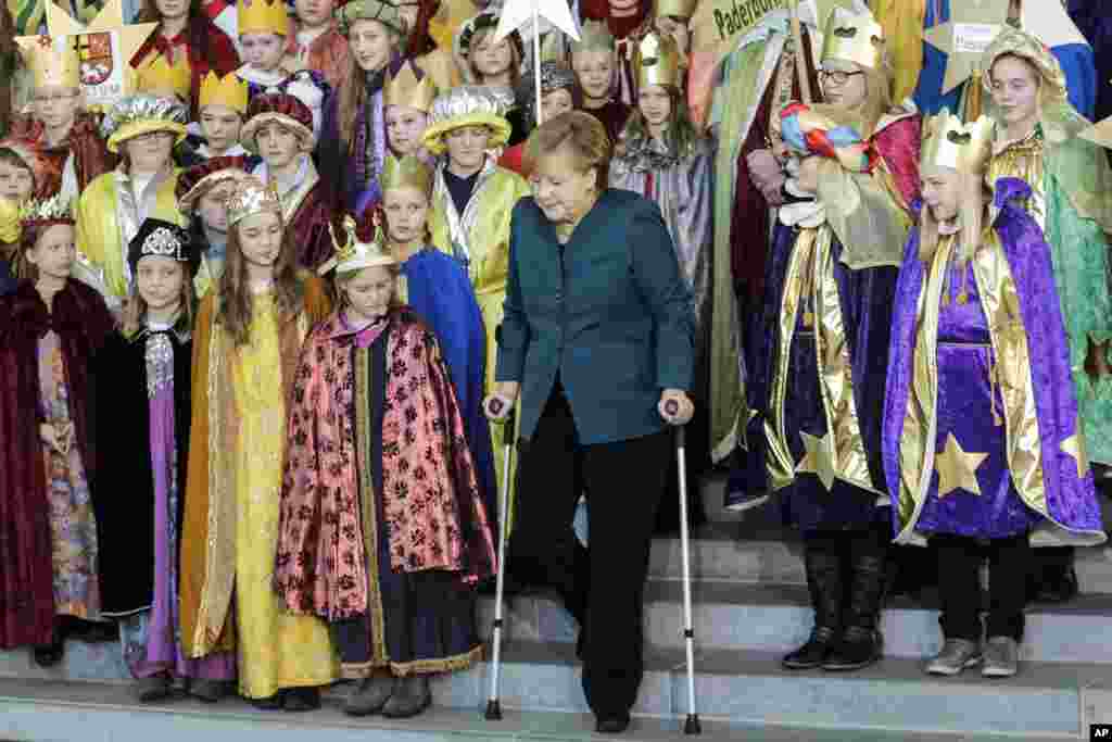 German Chancellor Angela Merkel uses crutches as she attends the annual reception for Carolers at the chancellery in Berlin. Merkel suffered a pelvis injury during ski holidays in the Swiss Alps and will have to cut back on her work schedule for the next three weeks.