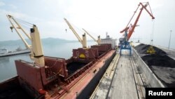 FILE - A cargo ship is loaded with coal at the North Korean port of Rajin, July 18, 2014. 