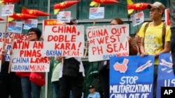 Police guard the entrance to the Chinese Consulate as environmental activists protest the alleged military build-up by China on the disputed group of islands at the South China Sea, Jan. 24, 2017 in the financial district of Makati east of Manila.