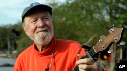 FILE - Folk singer Pete Seeger plays his banjo in Beacon, New York, May 5, 2006.