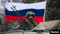 俄罗斯的装甲车行进在国旗前面。（资料照片）