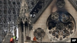 FILE - Experts inspect the damaged Notre Dame cathedral after the fire in Paris, Tuesday, April 16, 2019. So far, most of the money to fix it, is coming from the U.S. (AP Photo/Kamil Zihnioglu)