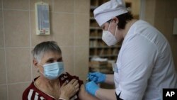 A medical worker administers a shot of Russia's coronavirus vaccine to an elderly woman in Korenovsk, Krasnodar region, 1,151 kilometers south of Moscow, Russia, Saturday, Nov. 13, 2021. The chief doctor of the region introduced compulsory vaccination aga