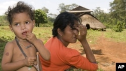 An ethnic minority Cambodian boy, left, stands next to his mother at a village in Mondul Kiri province some 265 kilometers (165 miles) northeast Phnom Penh, file photo. 