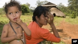 An ethnic minority Cambodian boy, left, stands next to his mother at a village, file photo. 