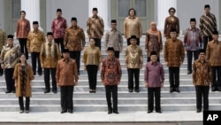 Indonesian President Joko Widodo, front row, center, and his deputy Jusuf Kalla, front row, second right, pose with the newly appointed cabinet ministers after their the inauguration ceremony at the presidential palace in Jakarta, Indonesia, Oct. 27, 2014