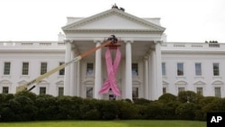 A pink ribbon to recognize breast cancer awareness is being hung on the north portico of the White House in Washington (File Photo)