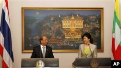 Visiting Myanmar President Thein Sein, left, shares a light moment with Thai Prime Minister Yingluck Shinawatra during a press conference at Government House in Bangkok, Thailand, Monday, July 23, 2012. (AP Photo/Rungroj Yongrit, Pool)