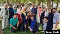 نوید خانجانی (پیراهن سرمه‌ای در وسط) با دوستان و خانواده بعد از آزادی. 