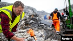 Geologist Anders Norby-Lie of the company Greenland Anorthosite Mining checks drilling cores at an exploration site of an anorthosite deposit close to the Qeqertarsuatsiaat fjord, Greenland, September 11, 2021. REUTERS/Hannibal Hanschke