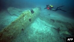 A French military diver member of the FS Pluton M622 navy de-mining ship, swims, July 2, 2018, above the wreck of an USAAF P-47 Thunderbolt (Warthog) U.S. fighter plane, which crashed in 1944 during the World War II, off the French Mediterranean island of Corsica.