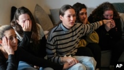 Freed hostage Shani Goren, right, and friends of Israeli hostage Arbel Yehoud react as they watch the broadcast of her being released from Hamas captivity, in Carmei Gat, southern Israel, Jan. 30, 2025.