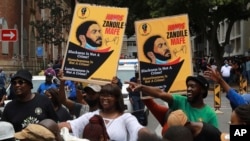 FILE - Supporters of Zandile Mafe protest outside the Magistrates Court in Cape Town, South Africa, January 11, 2022 Mafe is charged with terrorism two counts of arson, theft, housebreaking and contravention of the National Key Points Acts for the fire that destroyed Parliament.