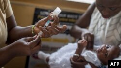 Seorang bayi perempuan menerima suntikan vaksin Malaria "Mosquirix" di sebuah klinik di Cape Coast, Ghana. 