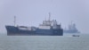2026年6月17日，一艘小型摩托艇驶过伊朗阿巴斯港附近的霍尔木兹海峡，与停泊在那里的船只擦肩而过。